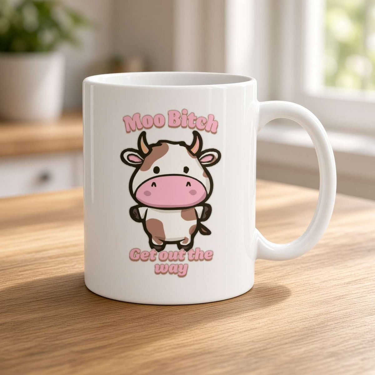 White mug on a sunlit wooden counter features a cute cartoon cow and pink text reading “Moo Bitch, Get out the way,” with a playful, cheeky tone.