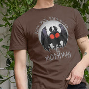 A man wearing a brown gaming T-shirt featuring a cartoon Mothman with red eyes, surrounded by the text 