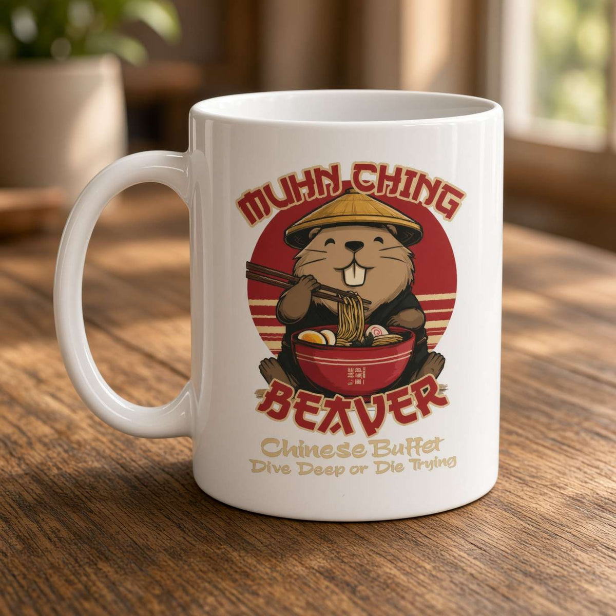 A white ceramic mug with a cartoon beaver eating ramen and the words “MUHN-CHING BEAVER” and “Chinese Buffet Dive Deep or Die Trying,” shown on a wooden table in a warm indoor setting.