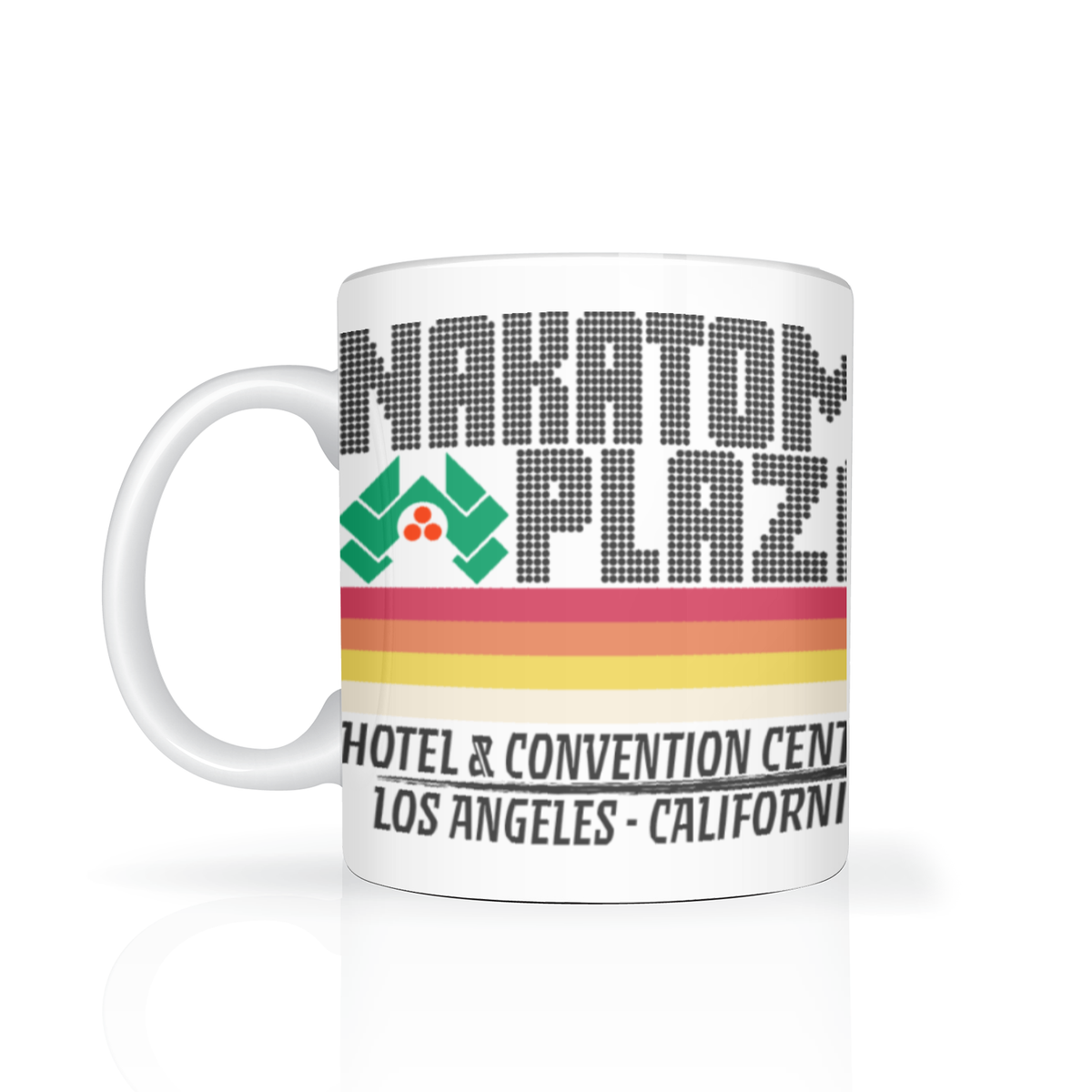 White ceramic mug featuring a retro pixel-style “Nakatomi Plaza” logo, green geometric emblem, colorful stripes, and text for a Los Angeles hotel; clean, nostalgic design.