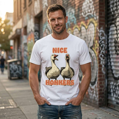 Man standing outdoors with hands in his pockets wearing a white Nice Honkers t-shirt featuring two cheeky geese, witty and slightly rude animal pun design
