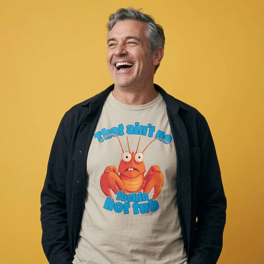 Man laughing with a black overshirt while wearing a beige That Ain’t No Fuckin Hot Tub t-shirt, rude mens lobster pun graphic design that every cheeky lad will claim
