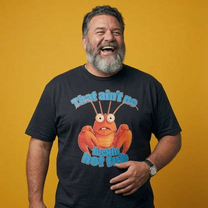 Man laughing with one hand on his stomach while wearing a black That Ain’t No Fuckin Hot Tub t-shirt, rude mens funny lobster pun graphic design full of pure attitude