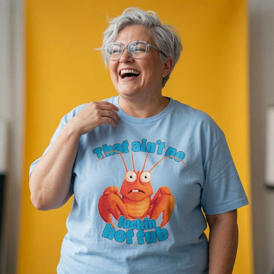 Woman laughing with one hand near her collar while wearing a blue That Ain’t No Fuckin Hot Tub t-shirt, funny ladies lobster pun graphic design that every no-nonsense lady will claim