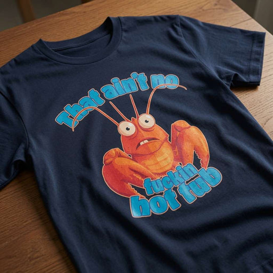 Navy That Ain’t No Fuckin Hot Tub t-shirt laid flat on a wooden surface showing the full cartoon lobster graphic, funny ladies offensive animal pun design full of pure attitude