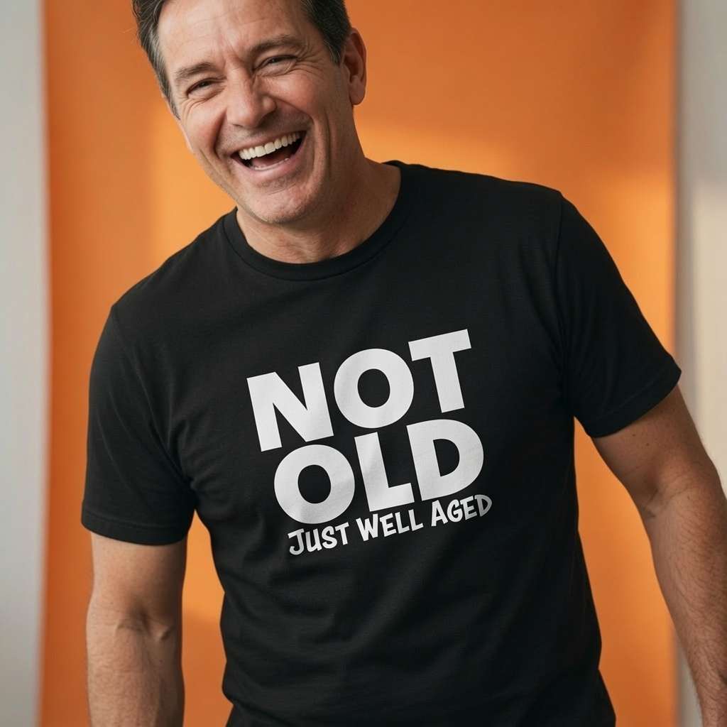 Man laughing while wearing a black Not Old Just Well Aged t-shirt, witty mens relatable old dad quote design that every cheeky lad will claim