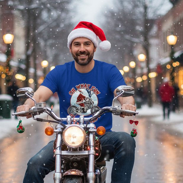 Man wearing a Santa hat and blue Biker Christmas t-shirt with a motorcycle graphic, sitting on a motorcycle in a snowy street.