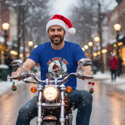 Man wearing a Santa hat and blue Biker Christmas t-shirt with a motorcycle graphic, sitting on a motorcycle in a snowy street.