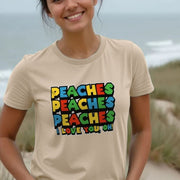 Smiling woman wearing a beige gaming shirt with colorful text 