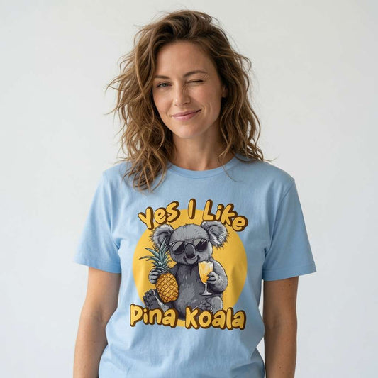 Woman winking while wearing a light blue Yes I Like Pina Koala t-shirt, funny and witty female animal graphic full of holiday energy