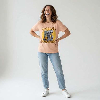 Woman laughing with hands on her hips while wearing a peach Yes I Like Pina Koala t-shirt featuring a cool koala in sunglasses holding a pineapple and cocktail, fun and witty ladies pineapple design