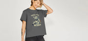 Smiling Woman wearing a grey funny T-shirt with a playful rhino graphic and 