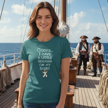 Smiling woman on a ship's deck wearing a teal shirt with nautical design and humorous text. Pirates in the background, ocean view, clear sky.