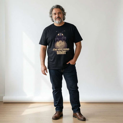 Bearded man with grey hair standing with one hand in his pocket while wearing a black I’ve seen some Shit! t-shirt featuring a dung beetle on a ball of dung, funny mens dung beetle pun graphic