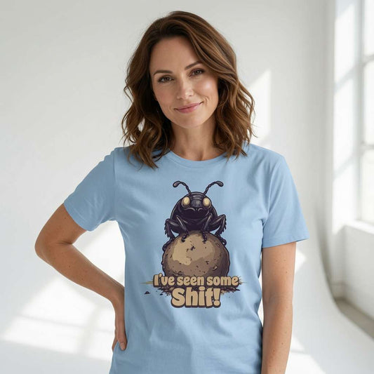 Woman smiling with one hand on her hip while wearing a blue I’ve seen some Shit! t-shirt with the full dung beetle graphic, funny insect pun full of pure attitude