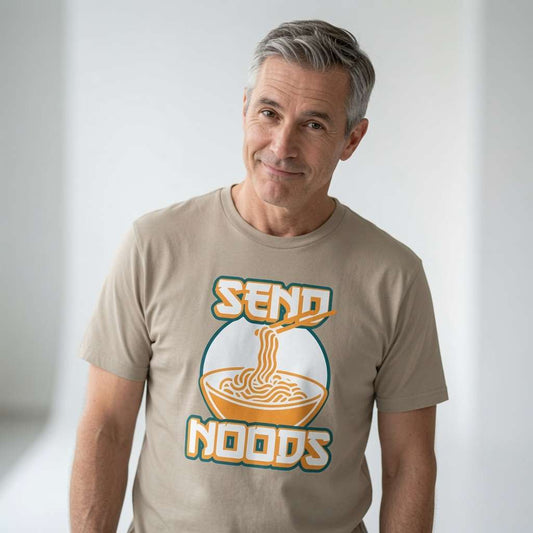 Grey-haired man smiling while wearing a stone Send Noods t-shirt featuring a steaming bowl of ramen, funny and witty ramen design