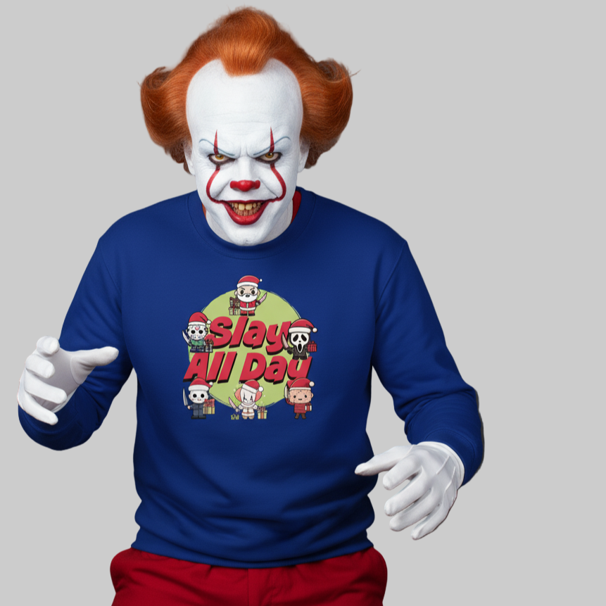 Clown with orange hair and sinister grin wears a blue Christmas sweater with festive-themed text "Slay All Day" and cartoon horror characters, evoking a playful yet eerie tone.