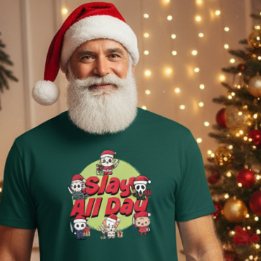 Man wearing a green alternative Christmas t-shirt with a Christmas horror themed graphic and Santa hat, standing in front of a decorated Christmas tree.