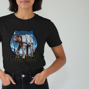 A Woman wears a black Movie T-shirt with a whimsical design of a cat as an AT-AT walker on a snowy landscape. Text below reads 