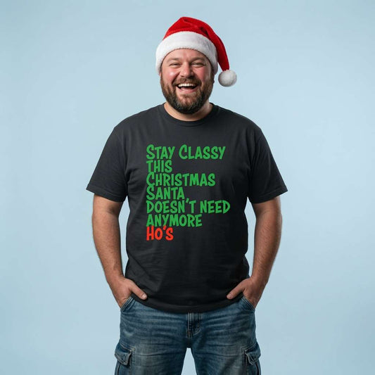 Bearded man in a Santa hat with hands in his pockets laughing in a black Stay Classy This Christmas Santa Doesn’t Need Anymore Ho’s t-shirt, funny mens witty xmas slogan that every festive lad will claim