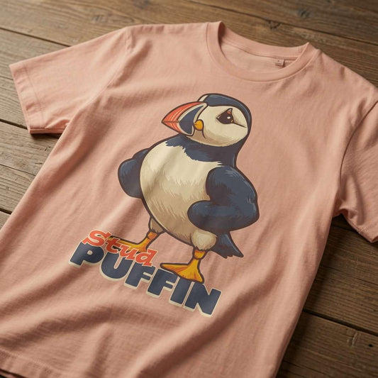 Peach Stud Puffin t-shirt laid flat on a wooden surface showing the full cartoon puffin, fun mens cheeky puffin pun that every cheeky lad will claim