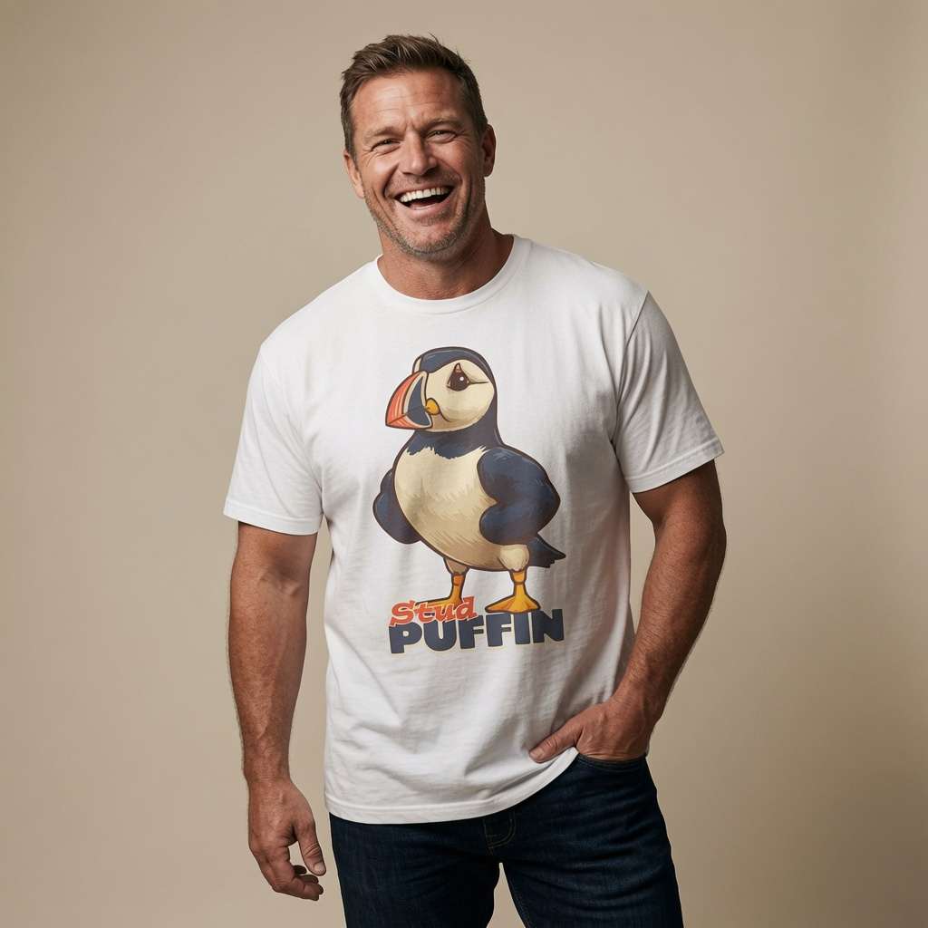 Man laughing with one hand in his pocket while wearing a white Stud Puffin t-shirt featuring a confident cartoon puffin, funny mens witty puffin pun