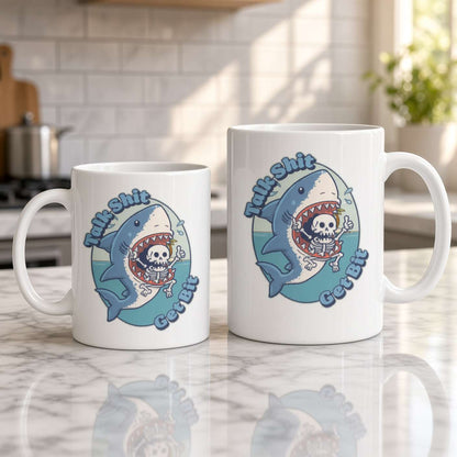 Two white ceramic mugs with a cartoon shark graphic sitting on a marble kitchen counter, with a blurred kitchen background.