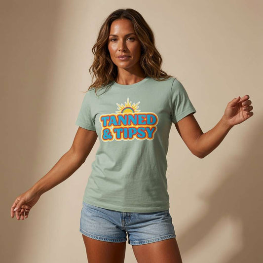 Woman looking at the camera with arms slightly out in an aloe Tanned & Tipsy t-shirt, fun ladies summer holiday slogan that every holiday-ready lady will claim