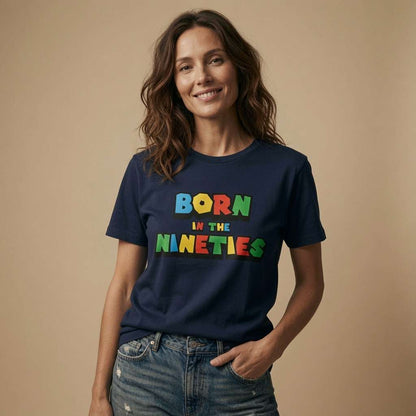 Woman smiling with one hand in her pocket in a navy Born in the Nineties t-shirt, ladies 90s gamer inspired fun age-related design full of pure attitude