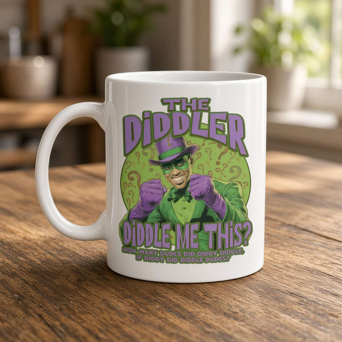 A white mug on a wooden kitchen counter features a grinning, green-and-purple comic-book character and playful “The Diddler” lettering, creating a quirky tone.