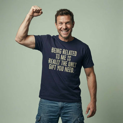 Man smiling and flexing one arm in a navy Being Related to Me is Really the Only Gift You Need t-shirt, mens xmas slogan tee and best Christmas present that every cheeky dad will claim
