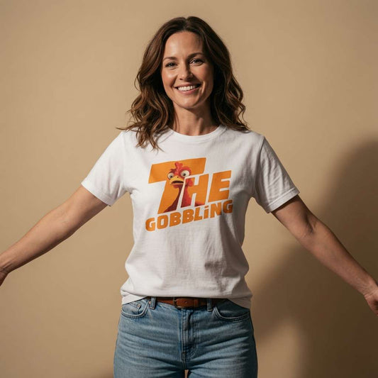 Woman smiling with arms outstretched while wearing a white The Gobbling t-shirt featuring a cartoon turkey head, funny ladies xmas day turkey design