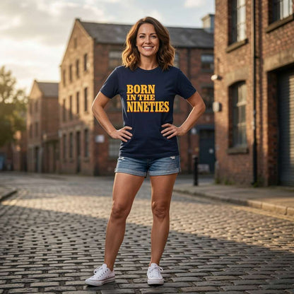 Woman standing with hands on her hips outdoors while wearing a navy Born in the Nineties t-shirt, ladies 90s film inspired born in statement design full of pure attitude