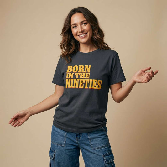 Woman smiling with arms outstretched in an ink grey Born in the Nineties t-shirt, ladies 90s film inspired born in slogan tee that every no-nonsense lady will claim