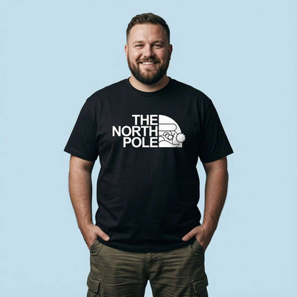 Bearded man smiling with hands in his pockets in a black The North Pole t-shirt, funny Santa pub banter shirt full of pure attitude