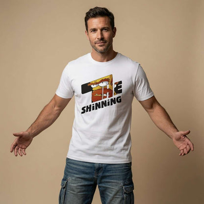 Man standing with arms outstretched while wearing a white The Shinning t-shirt featuring a cartoon character graphic, mens humorous and witty inspired by horror design