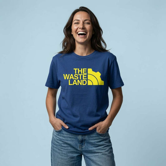 Woman laughing with hands in her pockets in a worker blue The Wasteland t-shirt, vault shirt full of pure attitude