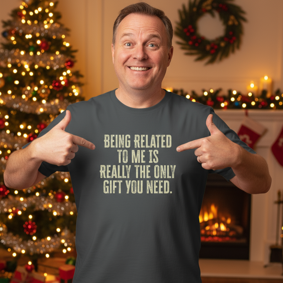 Man pointing to the ultimate Christmas Gift t-shirt with a humorous message in a festive setting with Christmas decorations.