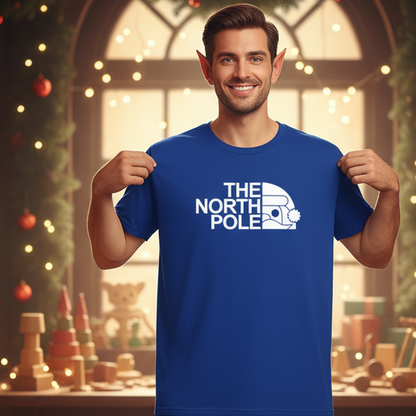 An elf wearing a blue t-shirt with 'The North Pole' print in a festive setting