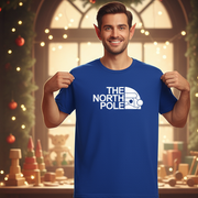 An elf wearing a blue t-shirt with 'The North Pole' print in a festive setting