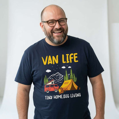 Bald man with glasses smiling while wearing a navy Van Life Tiny Home Big Living t-shirt, mens camper van camping camp site graphic design full of pure attitude
