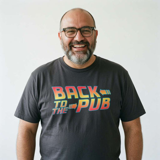 Bald man with glasses and beard smiling while wearing a black Back to the Pub t-shirt, retro witty and fun pub slogan mens tee full of pure attitude
