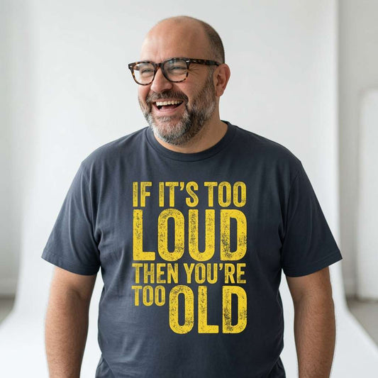 Bald man with glasses laughing while wearing an ink grey If It’s Too Loud Then You’re Too Old t-shirt, funny dad slogan design