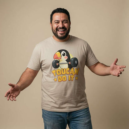 Man laughing with both arms out in a stone Toucan Do It t-shirt, fun bird design that every cheeky lad will claim