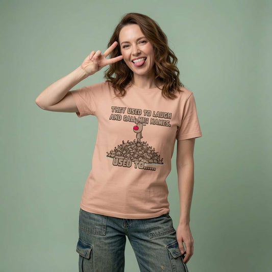 Woman sticking her tongue out and making a peace sign in a peach They Used to Laugh and Call Him Names t-shirt, witty ladies psycho reindeer design full of pure attitude