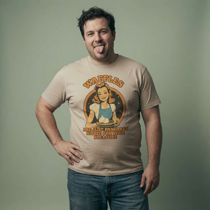 Man sticking his tongue out with one hand on his hip in a beige Waffles Are Just Pancakes Ribbed for Your Pleasure t-shirt, mens funny and cheeky retro vintage graphic shirt that every cheeky lad will claim