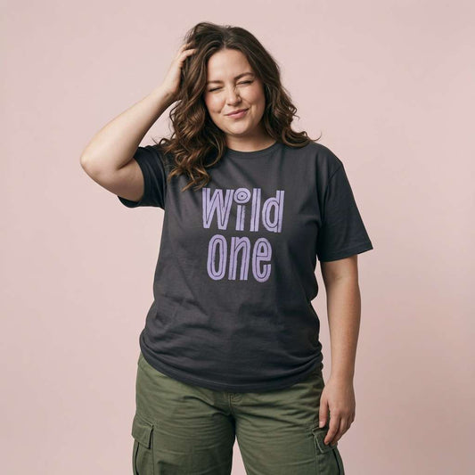 Woman winking with one hand in her hair while wearing a black Wild One t-shirt, funny matching couples shirt full of pure attitude