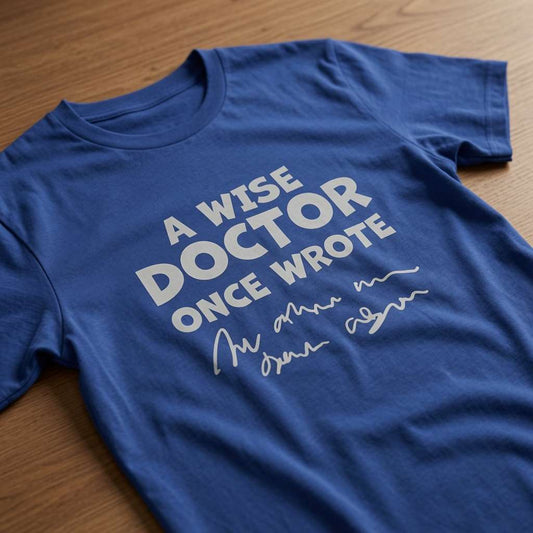 Worker blue A Wise Doctor Once Wrote t-shirt laid flat on a wooden surface showing the classic illegible doctor handwriting joke, fun mens cheesy dad joke design