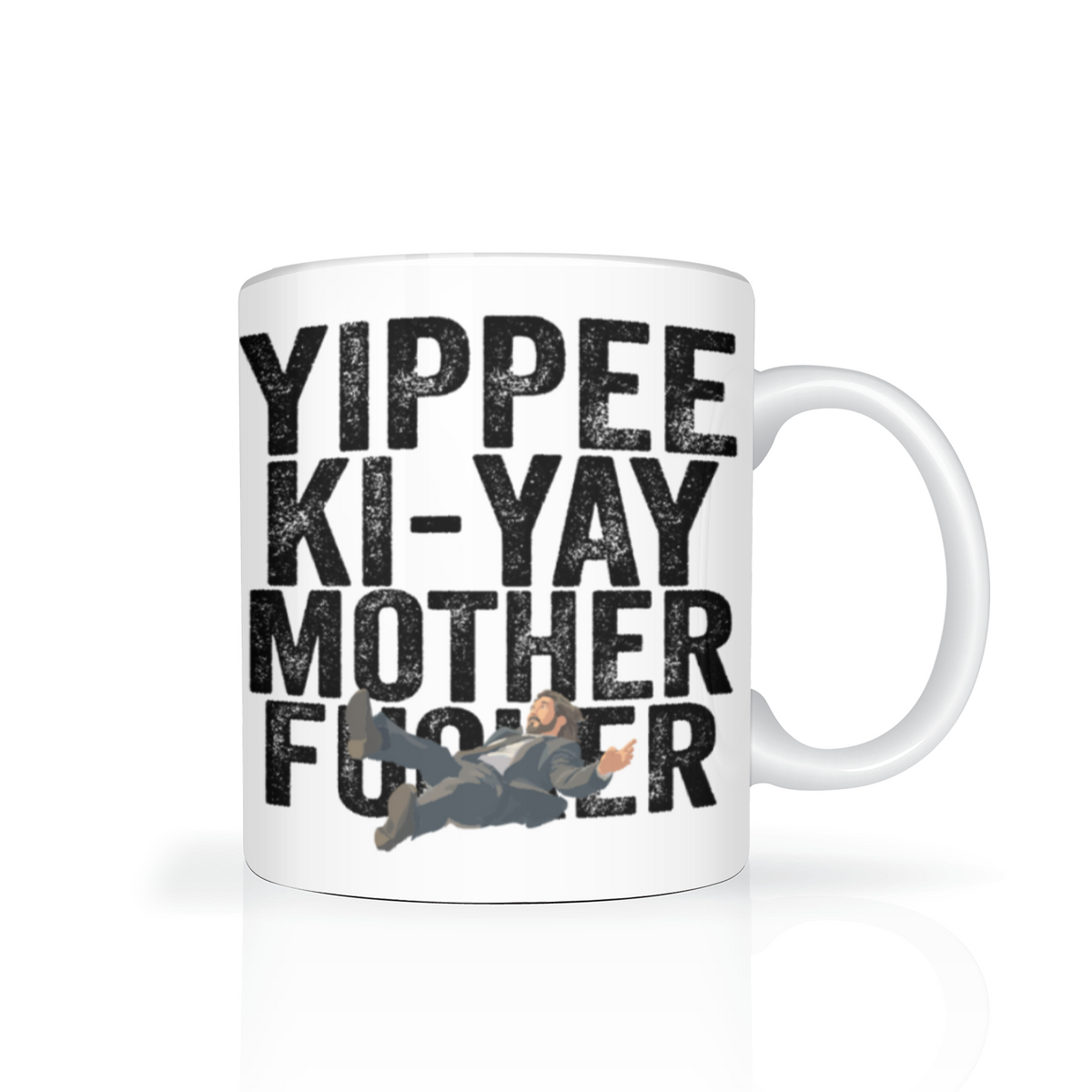 White ceramic mug with bold black “Yippee Ki-Yay Mother F—er” text and a small action-movie figure graphic, giving it a cheeky, irreverent tone.