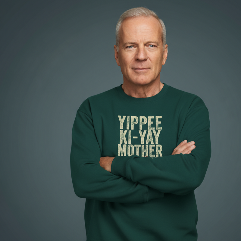 Man wearing a green Christmas sweatshirt with Yippee Ki-Yay Mother slogan on a gray background